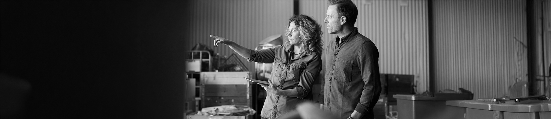 Schwarz-Weiß Bild wo eine Frau einem Mann etwas zeigt